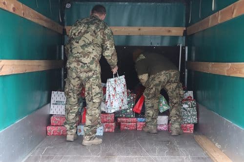Honvédségi tagok pakolják fel a kocsira a szentesi adománycsomagokat